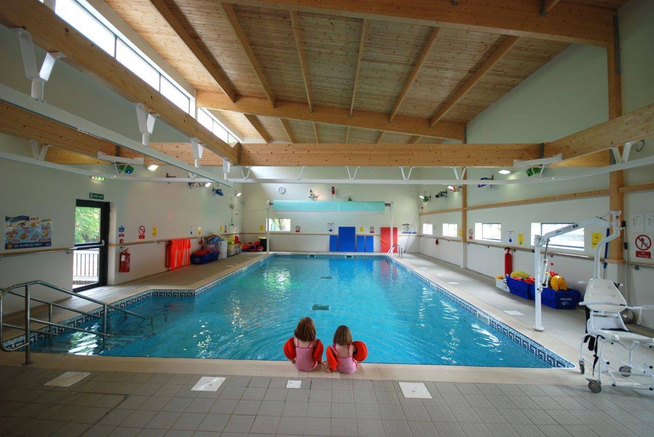 Two children sitting on the edge of the swimming pool