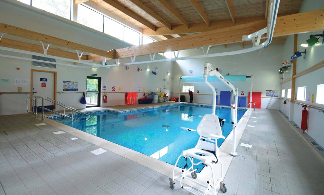 Indoor swimming pool with overhead electric hoist in foreground