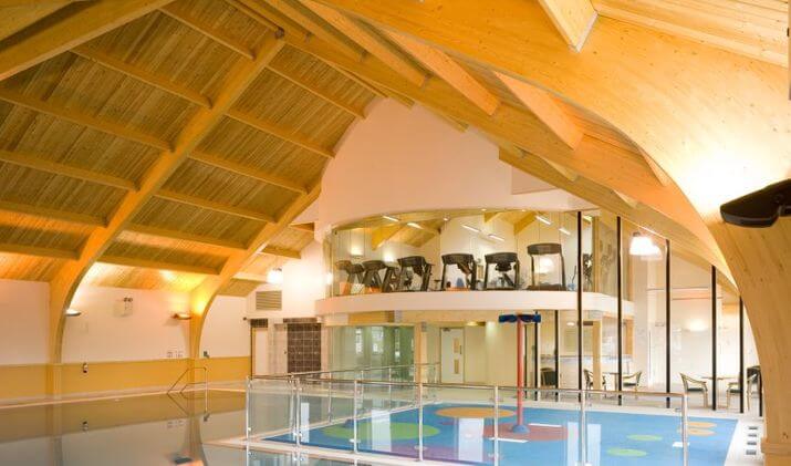 Interior view of indoor swimming pool and gym at Home Farm Holiday Park