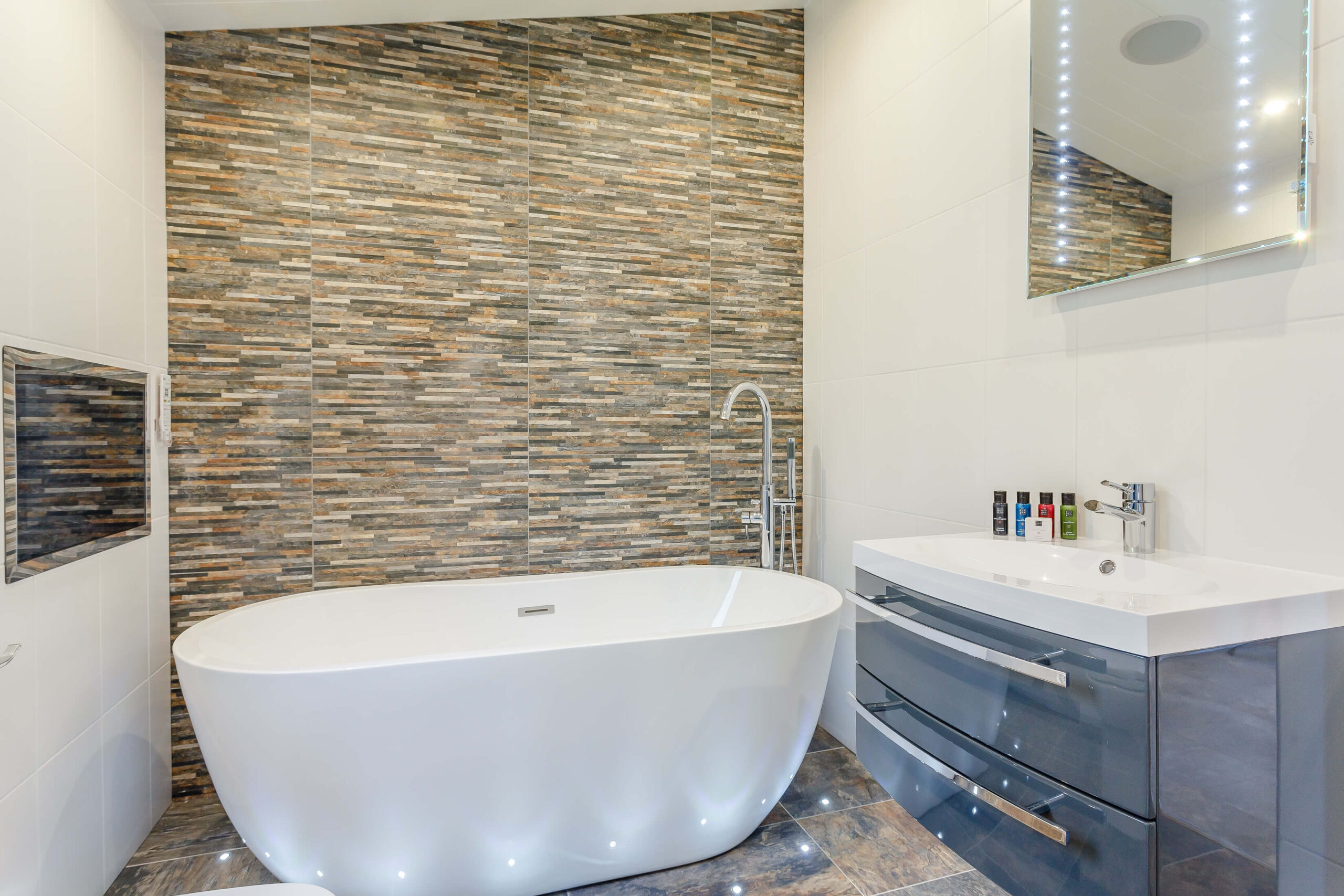 A bathroom with a free standing bath and sink