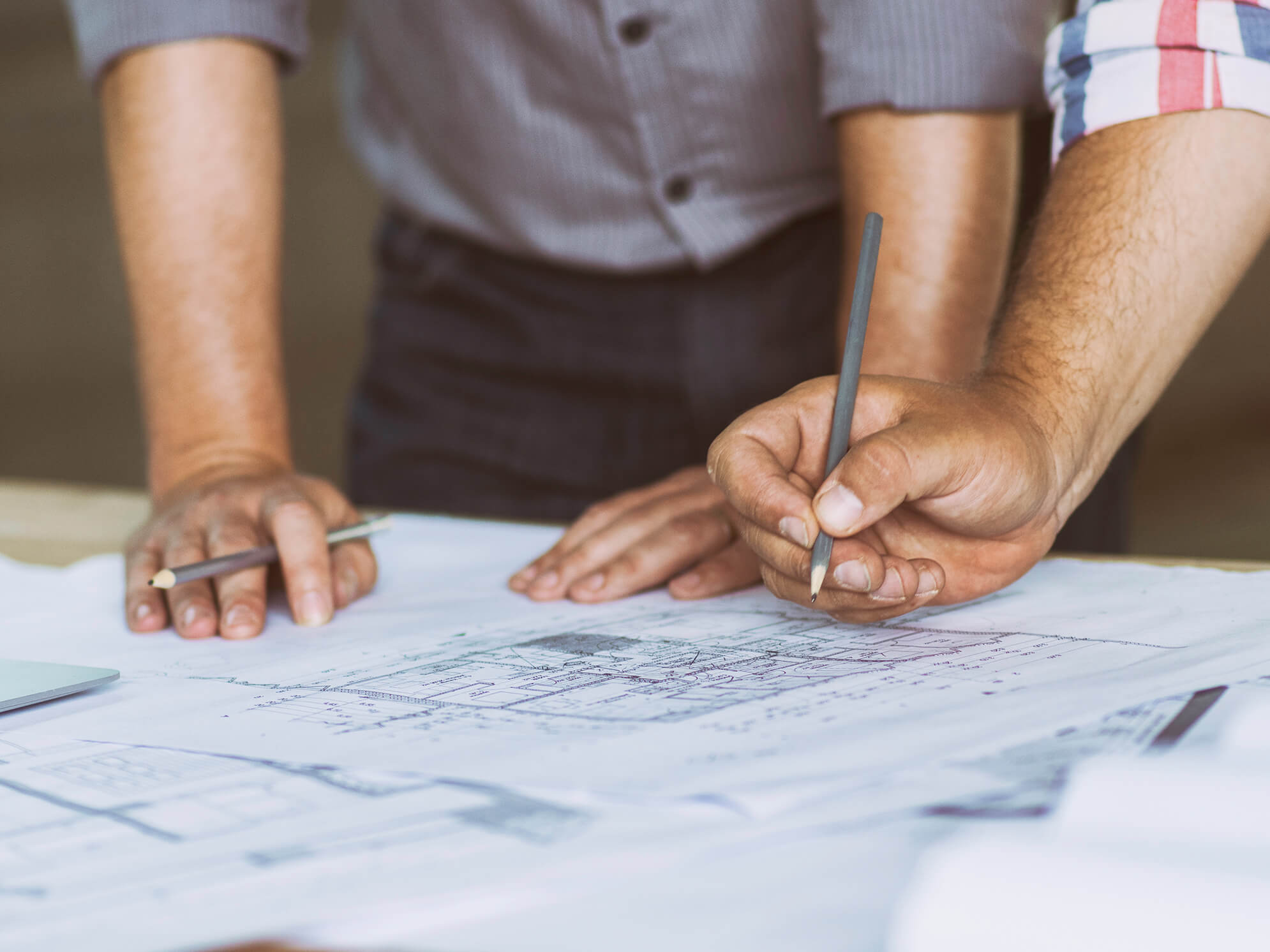 Close up of two peoples hand resting on an architects drawings